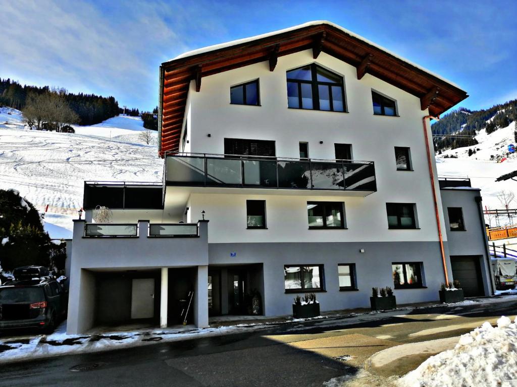 un grand bâtiment blanc avec un balcon dans la neige dans l'établissement Appartement Christine, à Grossarl