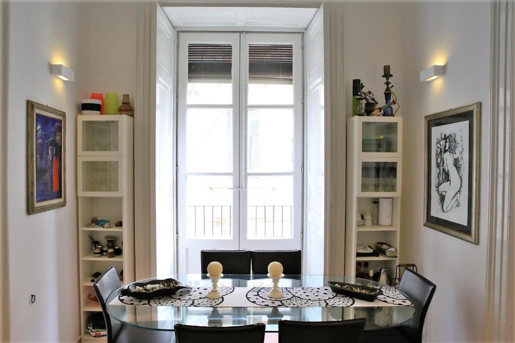 a dining room with a table and chairs and a window at Suite Il Letto Sotto Il Tetto in Catania