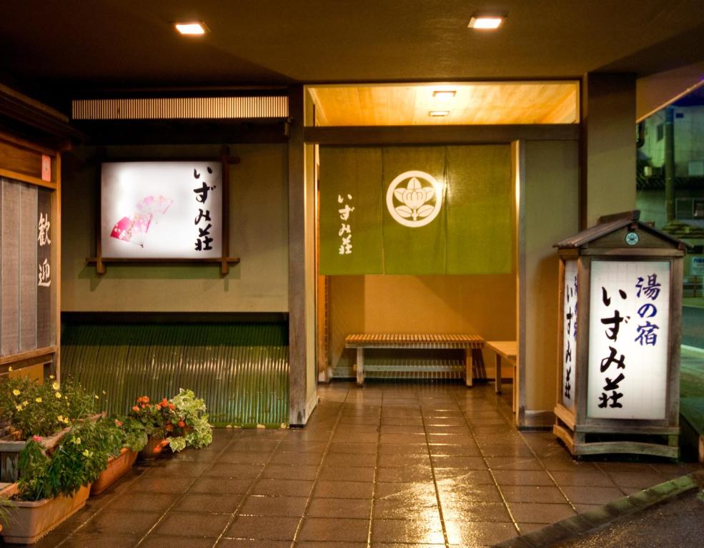 un bâtiment avec un banc et des panneaux sur le mur dans l'établissement Izumi-so, à Gero