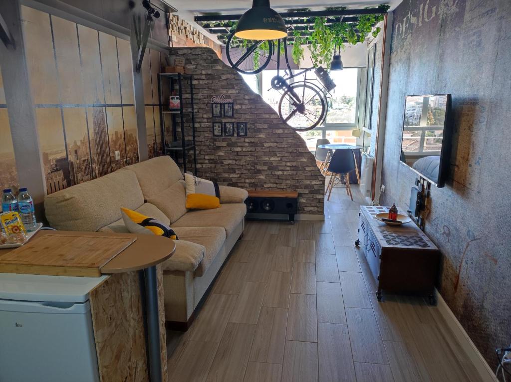 a living room with a couch and a table at Saltillo Alto Gray Studio. Vistas al mar y piscina in Torremolinos