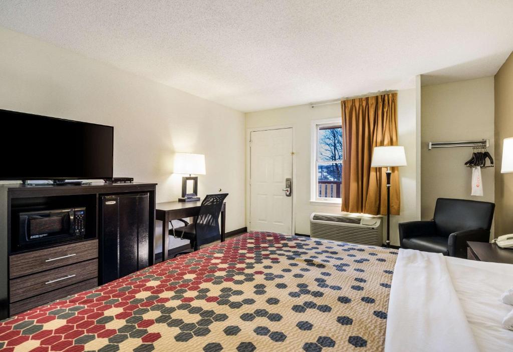 a hotel room with a bed and a flat screen tv at Econo Lodge Glade Springs I-81 in Glade Spring