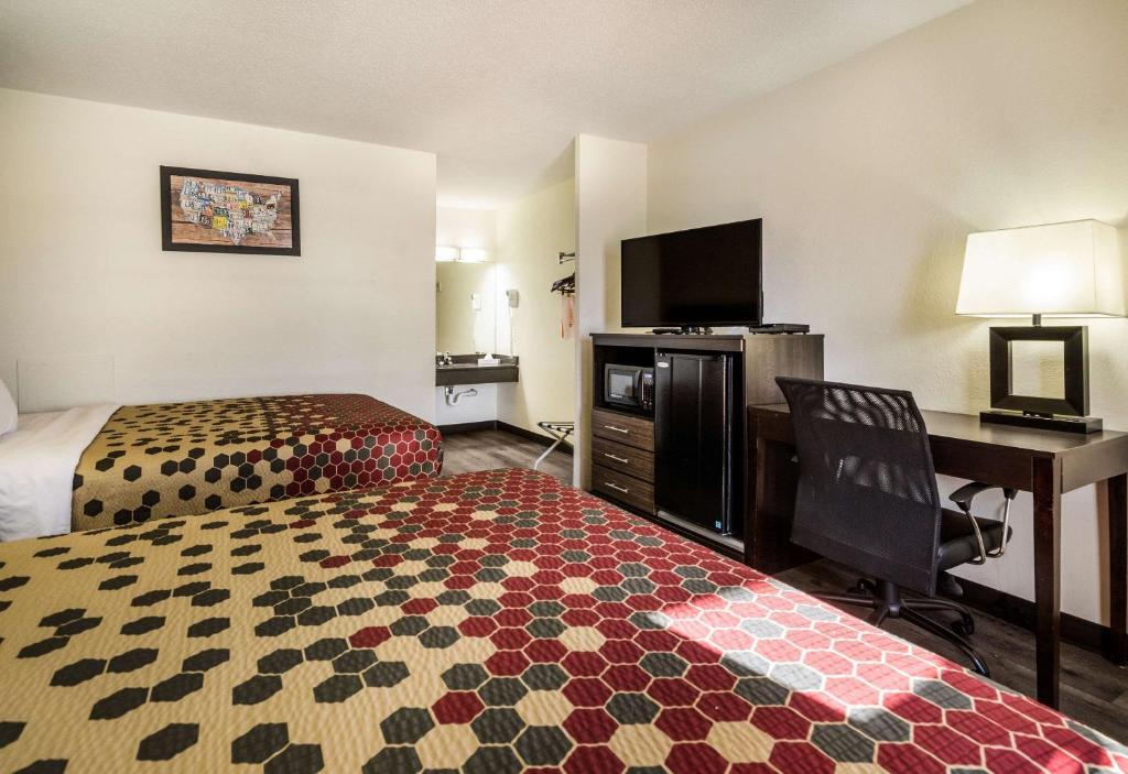 a hotel room with a bedroom with a bed and a desk at Econo Lodge Glade Springs I-81 in Glade Spring