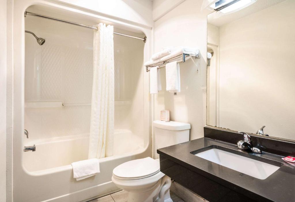 a bathroom with a sink and a toilet and a tub at Econo Lodge Glade Springs I-81 in Glade Spring