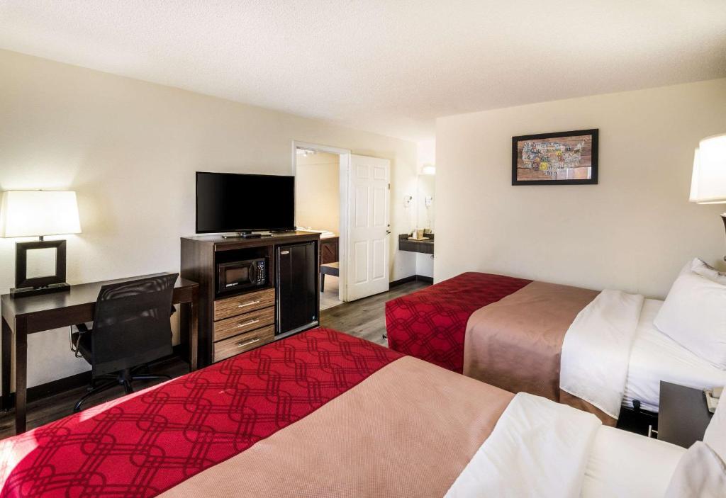 a hotel room with two beds and a flat screen tv at Econo Lodge Glade Springs I-81 in Glade Spring