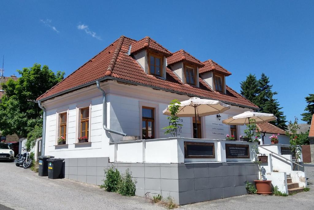 um edifício branco com um telhado vermelho numa rua em Apartmány Malý mnich em Mníšek pod Brdy