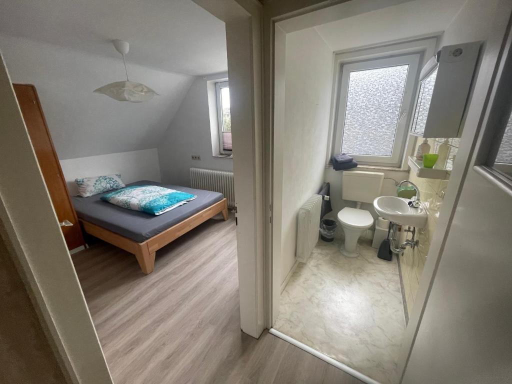 mała łazienka z łóżkiem i umywalką w obiekcie Monteurzimmer Zimmer + WC w mieście Willingen