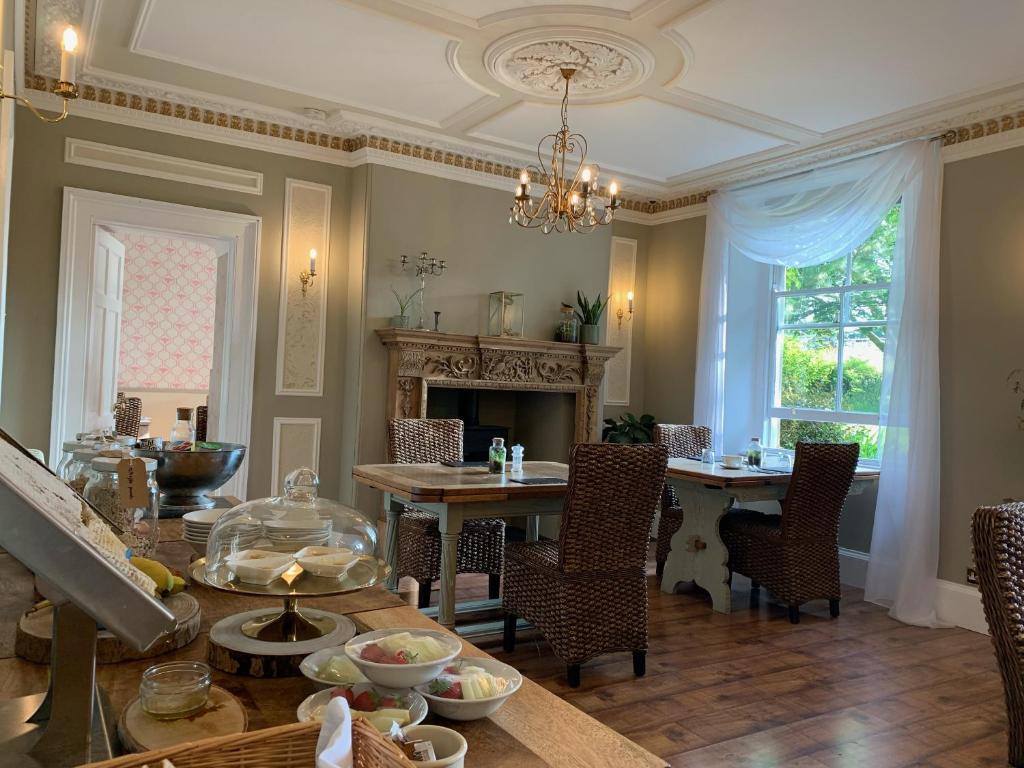 uma sala de jantar com uma mesa e uma lareira em Lydford House em Lydford
