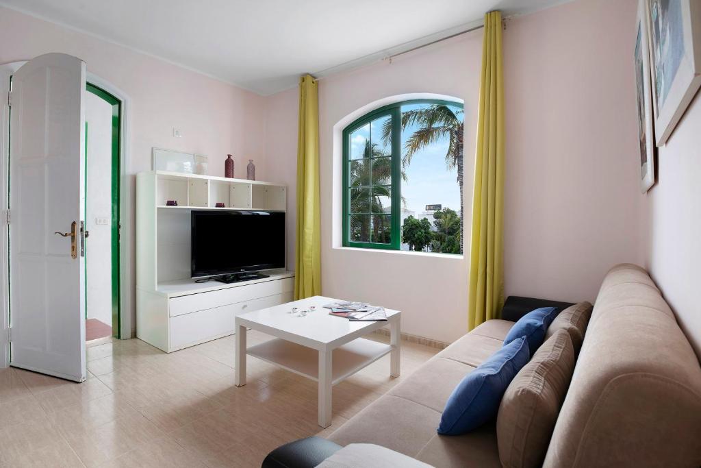 salon z kanapą i stołem w obiekcie Apartamento Rocas Negras w Puerto del Carmen