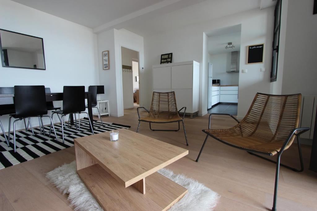 a living room with a wooden table and chairs at Le Normandy in Pourville-sur-Mer