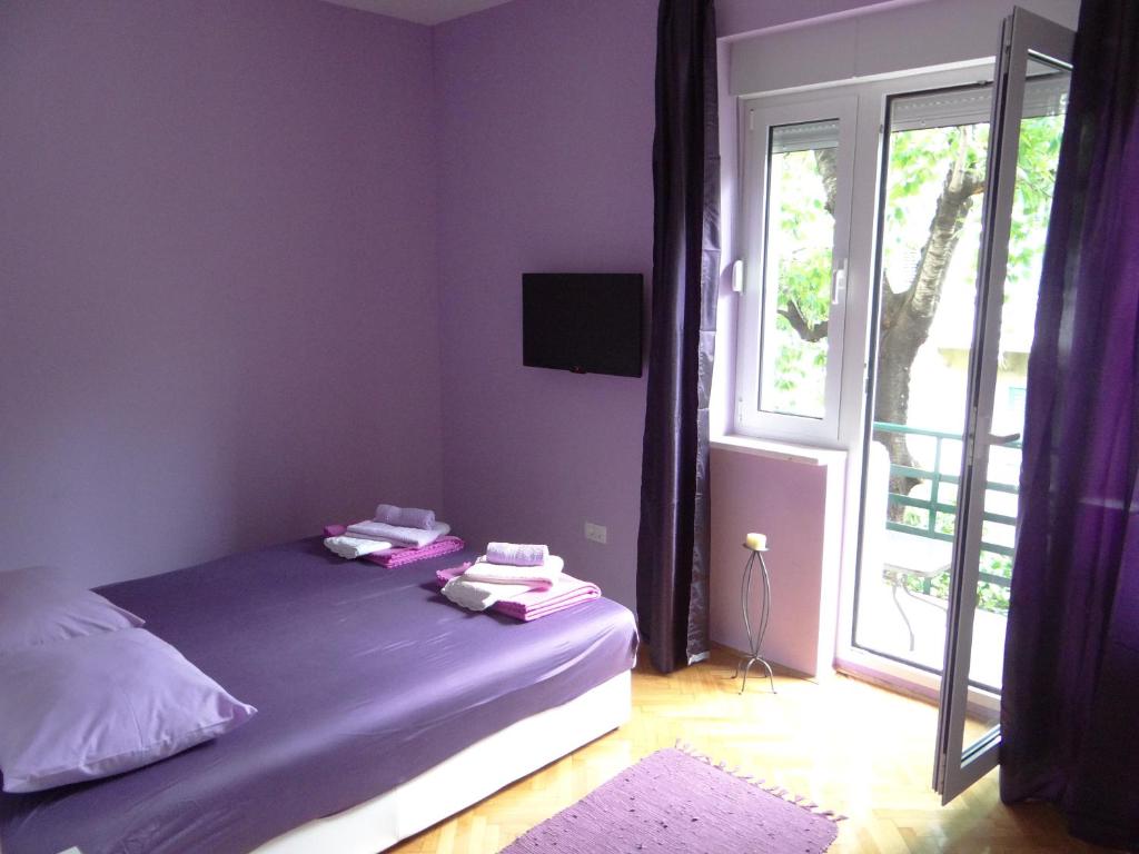 1 dormitorio con 1 cama con paredes de color púrpura y ventana en Rooms Stella, en Split