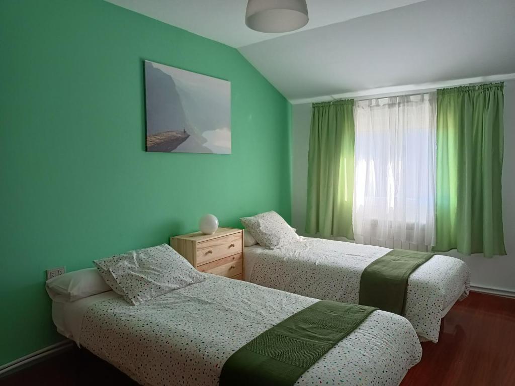 2 camas en una habitación con paredes verdes en Vista Estrelada, en Requeixo