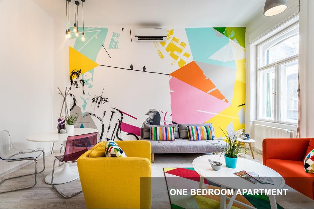ブダペストにあるBpR Art of Rainbow Apartmentsのカラフルな家具とカラフルな壁が特徴のリビングルーム
