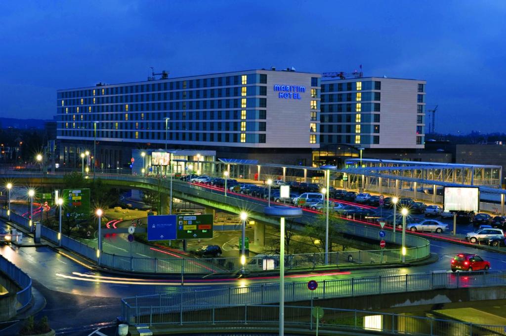 un gran edificio con luces frente a una autopista en Maritim Hotel Düsseldorf, en Düsseldorf