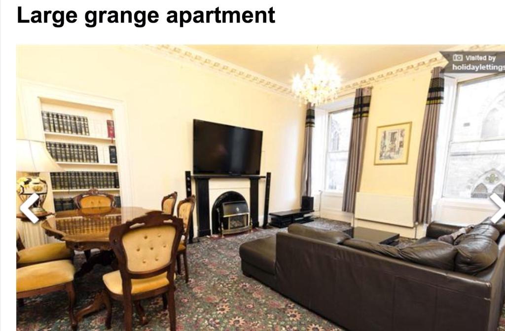 uma sala de estar com um sofá, uma mesa e uma televisão em Large Grange Apartment em Edimburgo