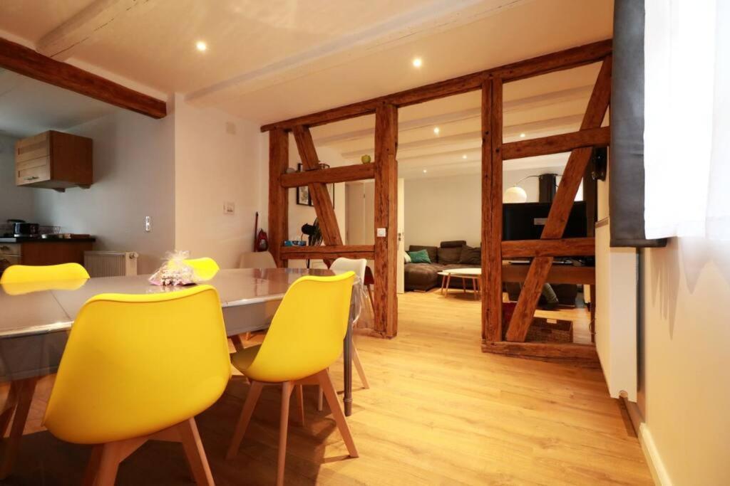 uma sala de jantar com uma mesa e cadeiras amarelas em Gîte Sainte Odile em Obernai