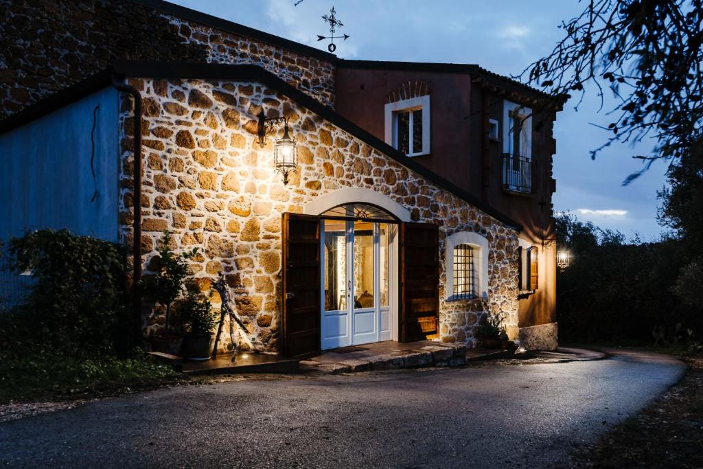 uma antiga casa de pedra com uma porta branca em La pagliera em Agrigento