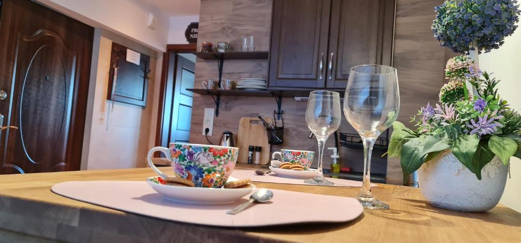 een tafel met twee wijnglazen en een bord met een kom bij Myśliwska 5a in Karpacz
