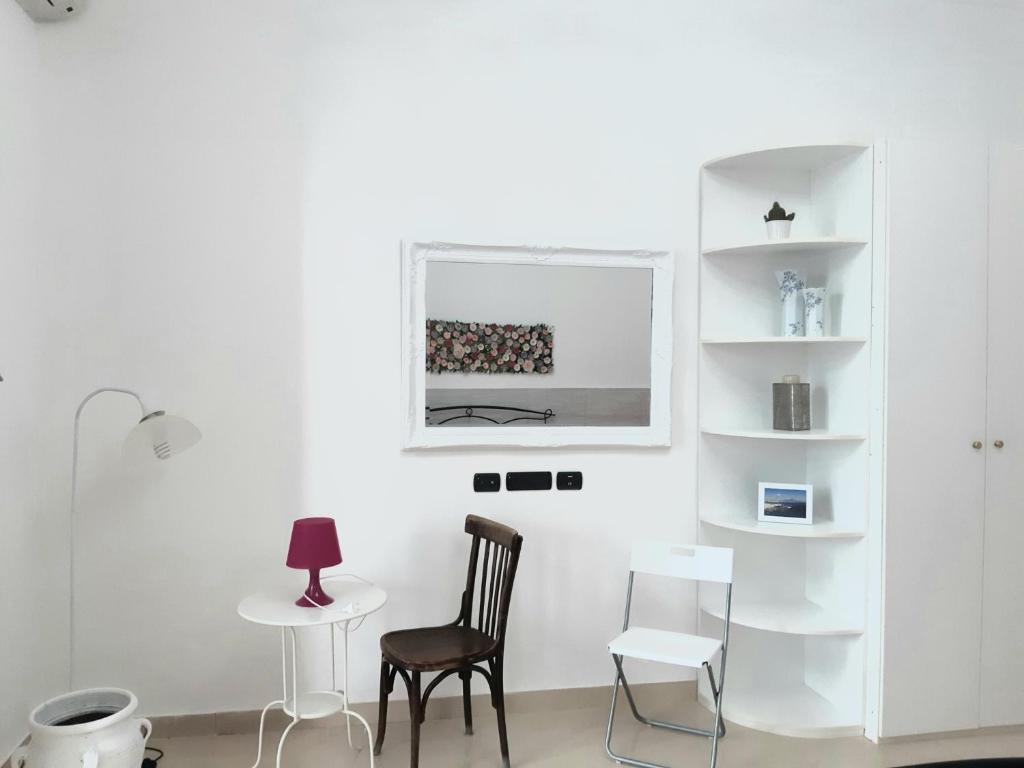 ein weißes Zimmer mit 2 Stühlen und einem Tisch in der Unterkunft Dimora Filangieri in Neapel
