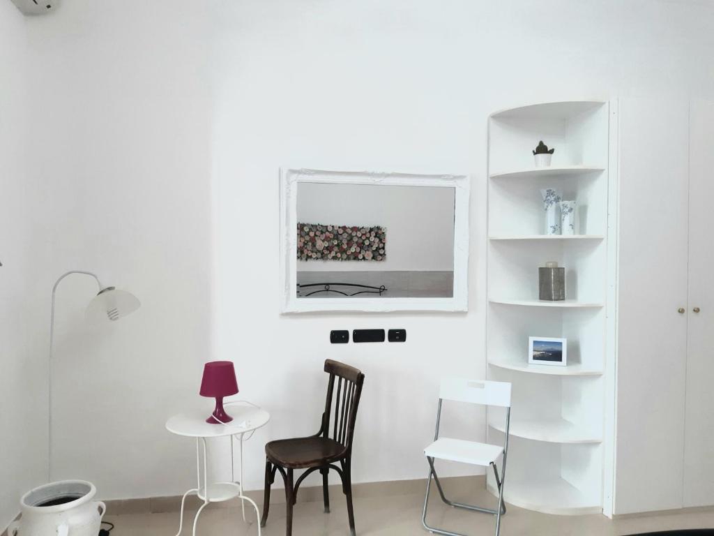 a white room with two chairs and a table at Dimora Filangieri in Naples