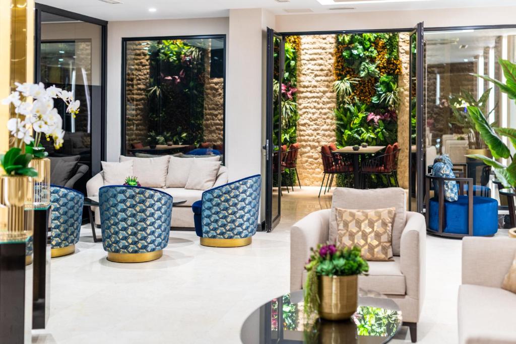 een lobby met stoelen, tafels en planten bij Aprilis Deluxe Hotel in Istanbul