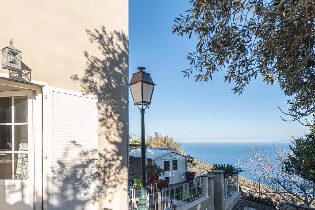 a street light in front of a house with the ocean in the background at casa dei zitelli studio de charme avec jardin et terrasse in Brando
