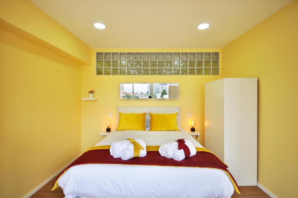a bedroom with a large bed with yellow walls at RH Charming Apartment Liberdade II in Braga