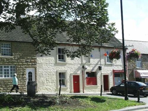 un hombre está caminando por una casa de piedra en The Old Post Office, Lanchester en Lanchester