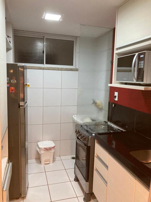 a small kitchen with a sink and a stove at Palm beach, Porto das dunas próximo ao Beach Park in Aquiraz
