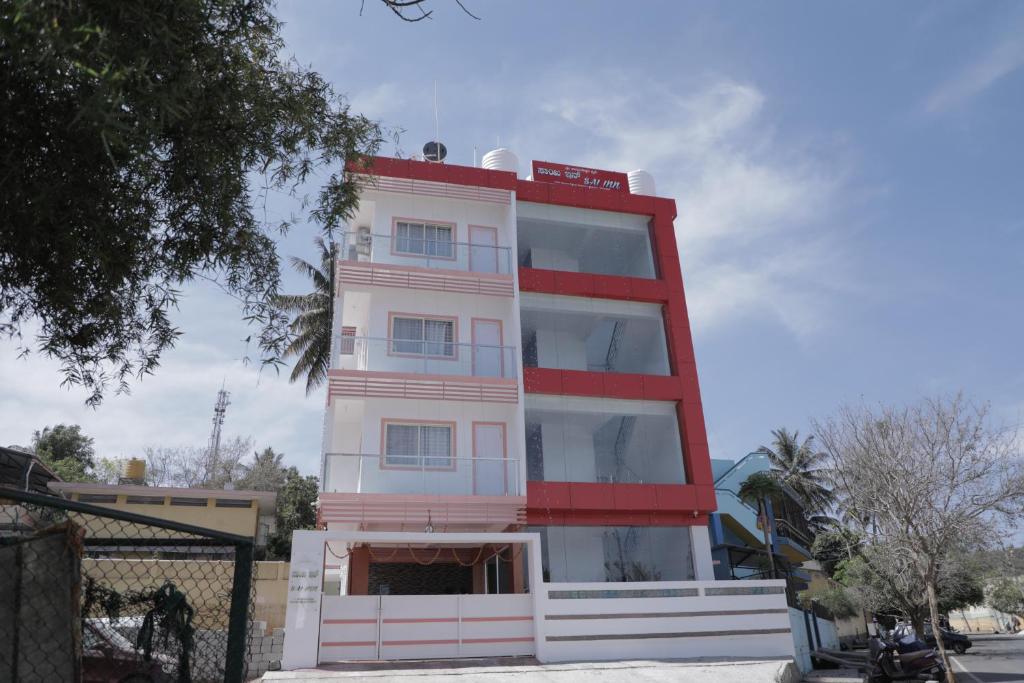 a tall white and red building at Sai Inn Mysore in Mysore