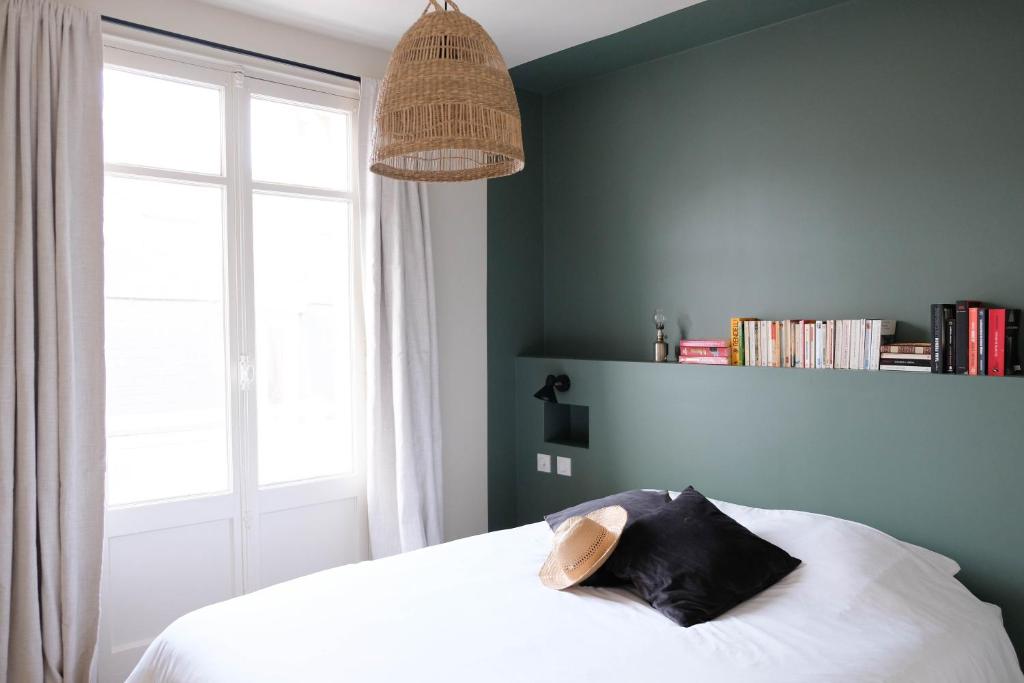 Villa Jeanne - Confort et plage في لو تريبور: غرفة نوم مع سرير مع قبعة عليه