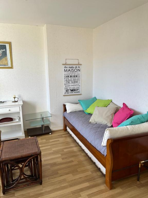 a room with two beds with colorful pillows at appartement spacieux et lumineux proche de la plage in Quimiac