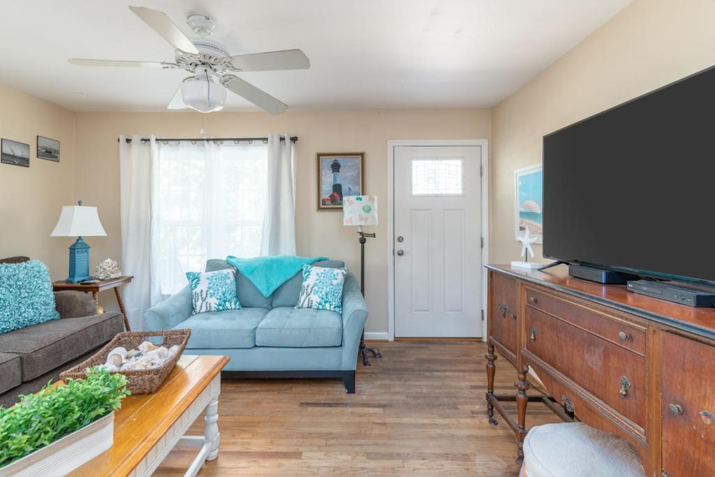een woonkamer met een blauwe bank en een flatscreen-tv bij Palmwood Paradise in Tybee Island