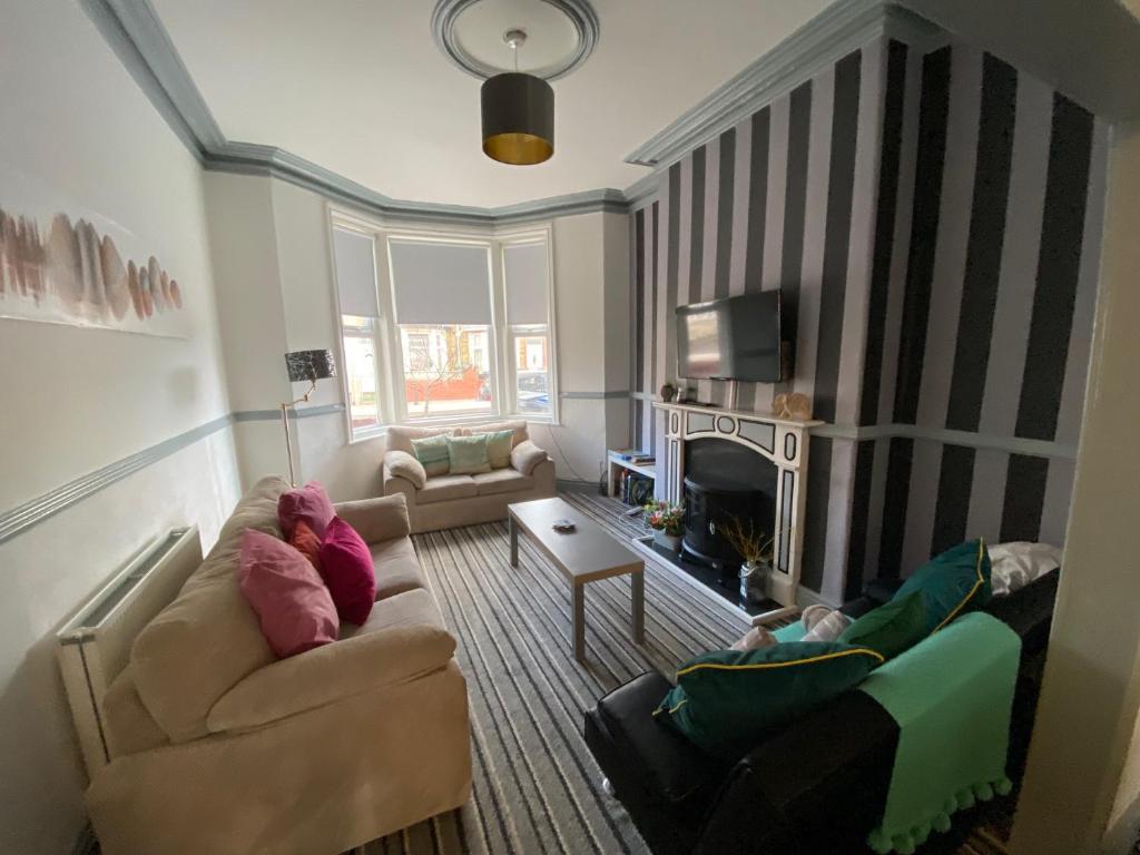 a living room with a couch and a tv at Blackpool Abode - Seaside Cove in Blackpool