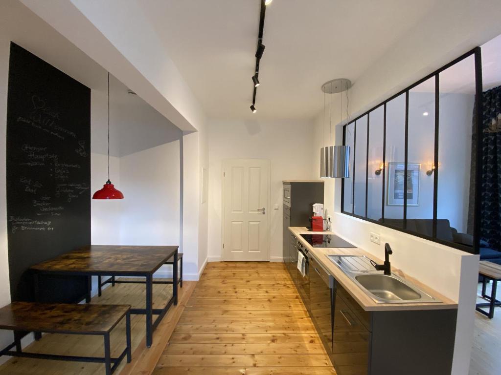 a kitchen with a sink and a counter and a table at URBAN STAY Hamburg - Apartments "BACKBORD" & "STEUERBORD" in Hamburg