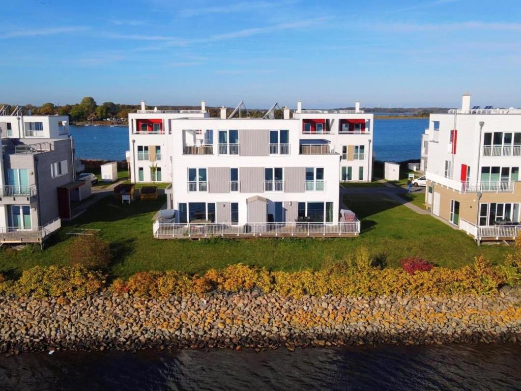 eine Luftansicht eines Hauses auf einer Insel im Wasser in der Unterkunft Schleivilla Lootsen Hus by Seeblick Ferien ORO, 3Etagen,8Pers,Sauna,Kamin in Olpenitz