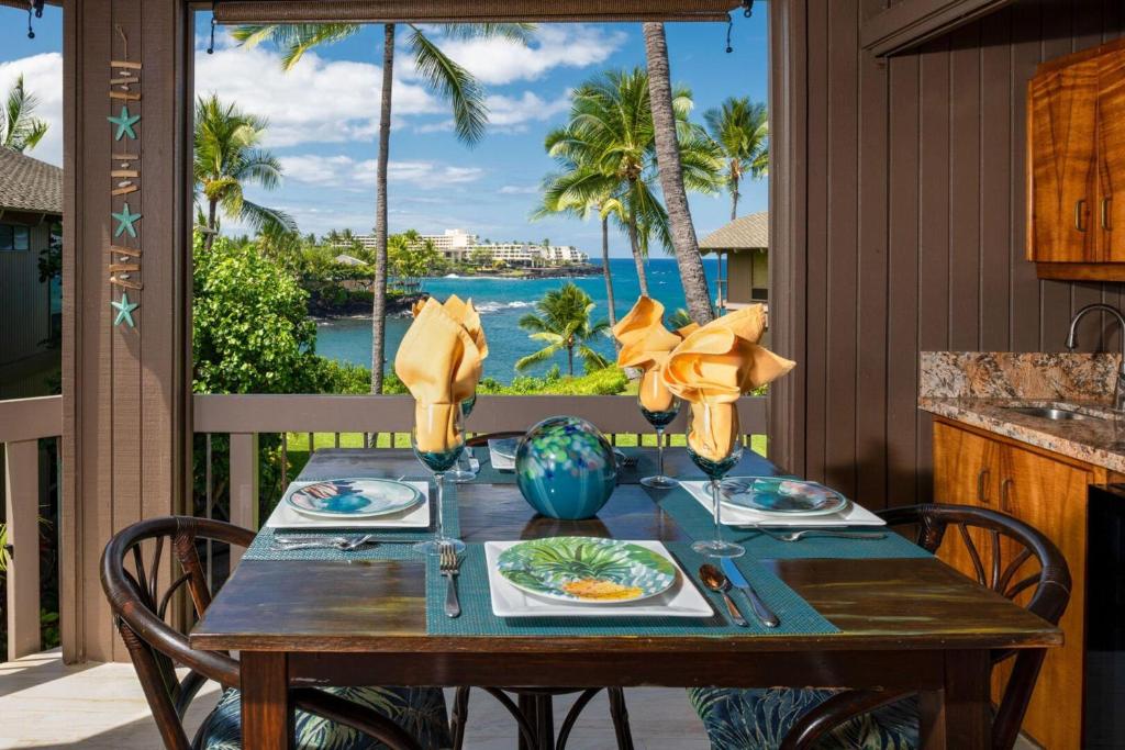einen Tisch auf der Veranda mit Meerblick in der Unterkunft Spacious & Inviting Kanaloa #3503 by Casago Kona - Come Play in Kailua-Kona