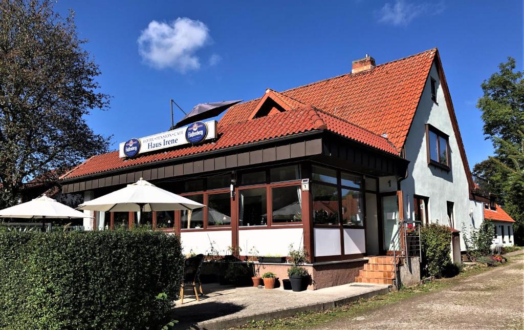 ein weißes Gebäude mit rotem Dach in der Unterkunft Hotel Pension Haus Irene in Hohwacht