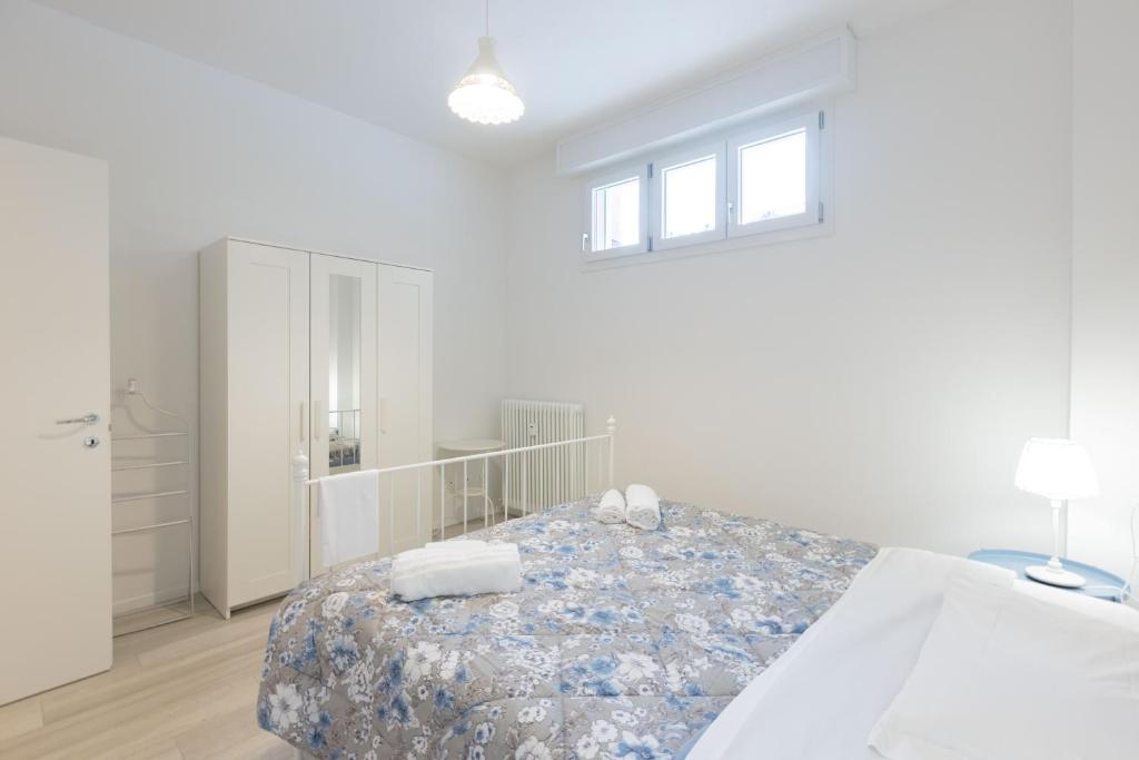 a white bedroom with a bed and a white cabinet at Andreini, Bologna by Short Holidays in Bologna