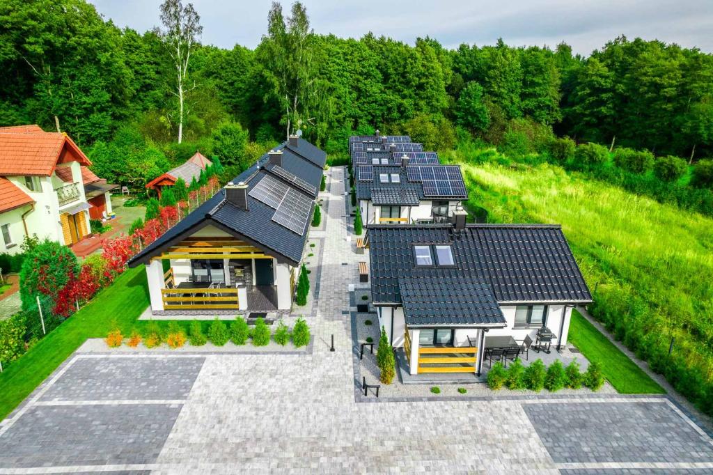 eine Aussicht auf ein Haus mit Sonnenkollektoren auf dem Dach in der Unterkunft Domki letniskowe - SEVEN in Dąbki