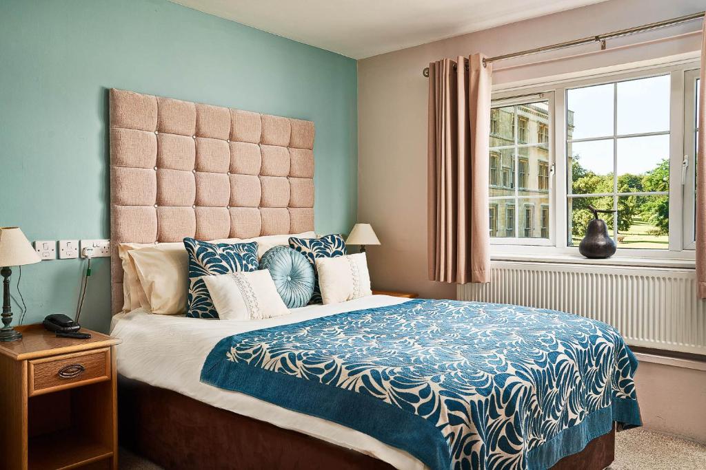 a bedroom with a bed with a blue and white comforter at The Garden Suite at Shuttleworth in Old Warden