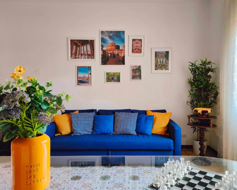 a living room with a blue couch and pictures on the wall at Non ti scordar di me - Granny's House in Rome