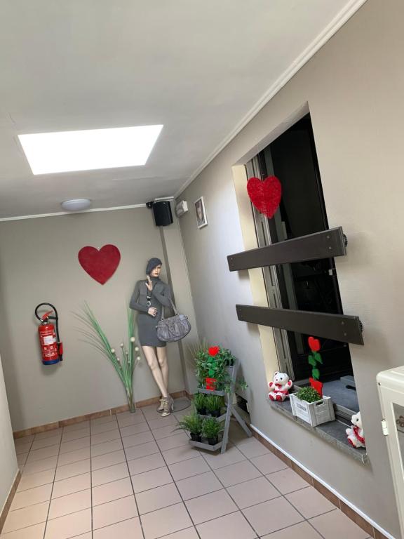 a woman standing in a room with hearts on the wall at Carpe Diem in Jumet