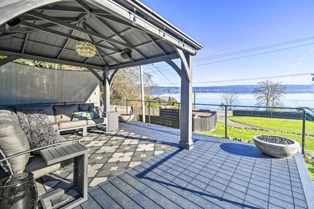 a pergola with a couch and a bench on a deck at Puget Sound Cabin with Hot Tub and Water Views! in Bremerton