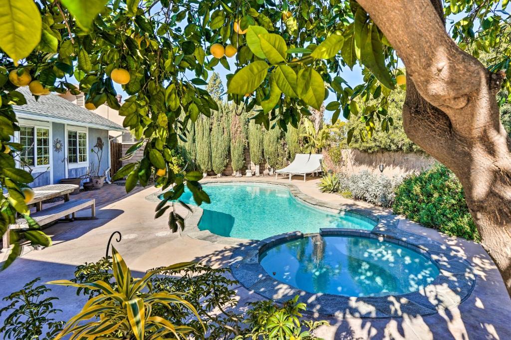 a swimming pool in a yard with an orange tree at Deluxe Laguna Hills Home with Outdoor Oasis! in Laguna Hills