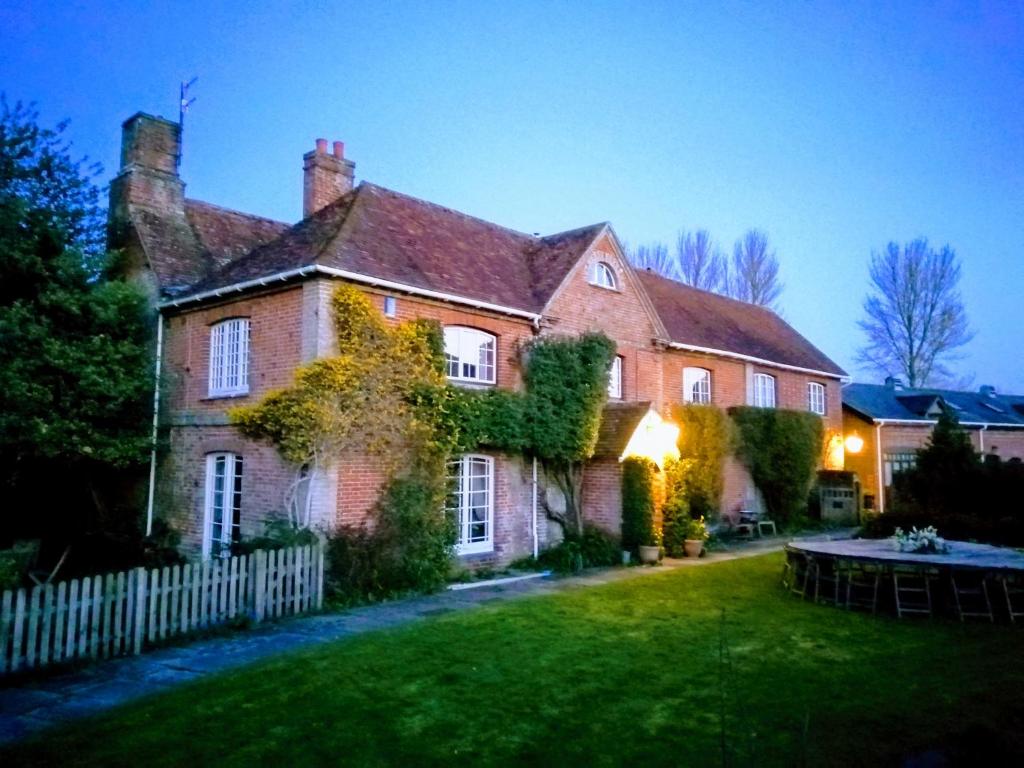 una gran casa de ladrillo con una valla en el patio en Bridge Farmhouse, en Salisbury