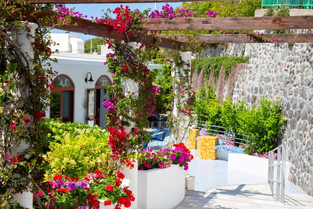 einen Garten mit Blumen in Töpfen vor einem Gebäude in der Unterkunft Hotel La Mandorla in Ischia