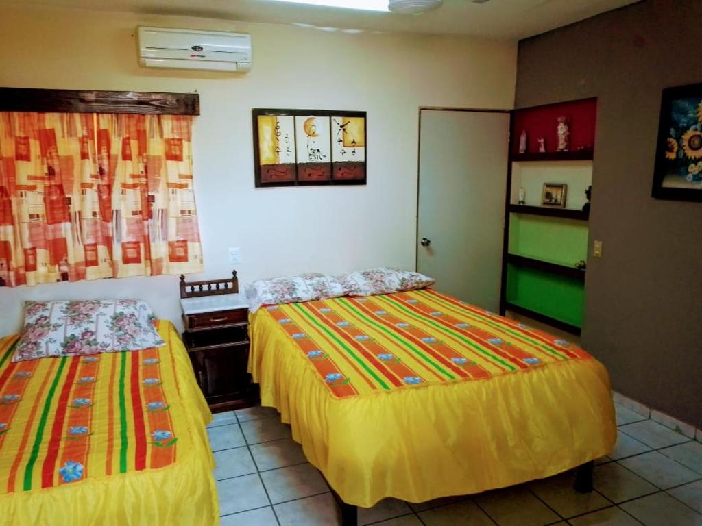 1 dormitorio con 2 camas en una habitación en Apartamentos osuna, en Mazatlán
