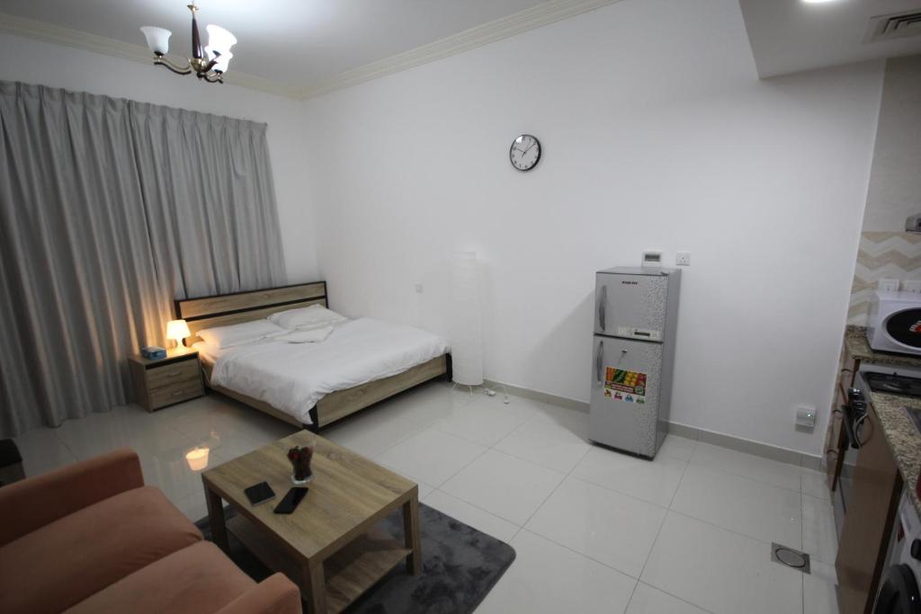 um pequeno quarto com uma cama e uma mesa de centro em Budget Rental Apartments in Dubai em Dubai