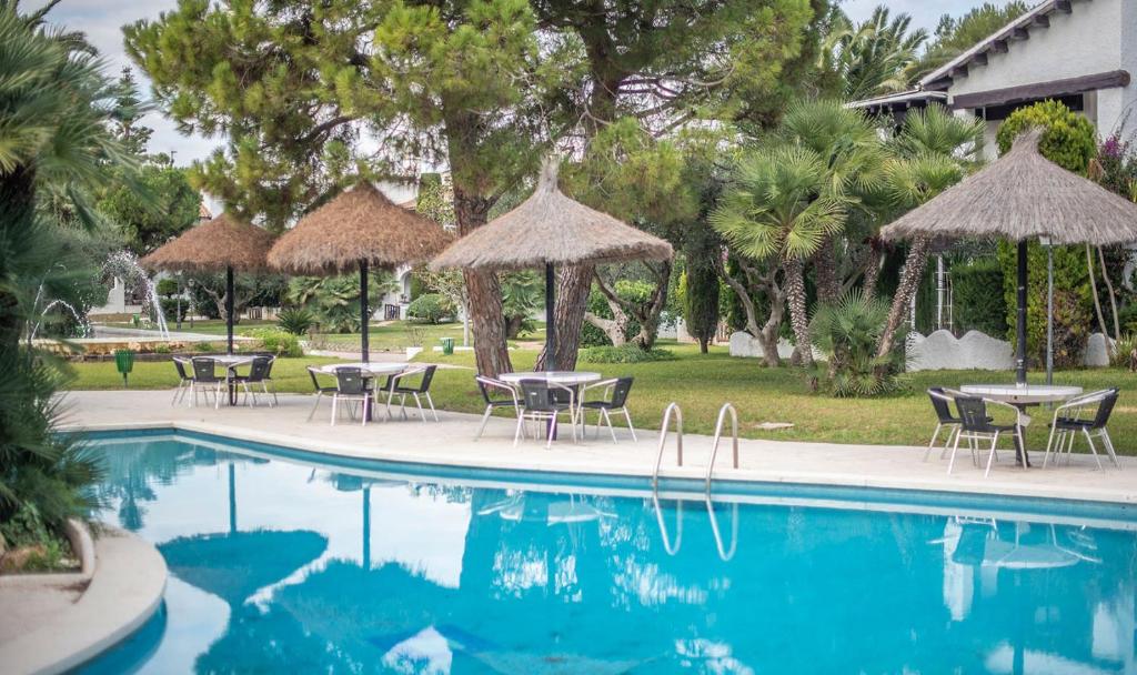 a pool with tables and chairs and umbrellas at R97 Casa Alorda in Calafell
