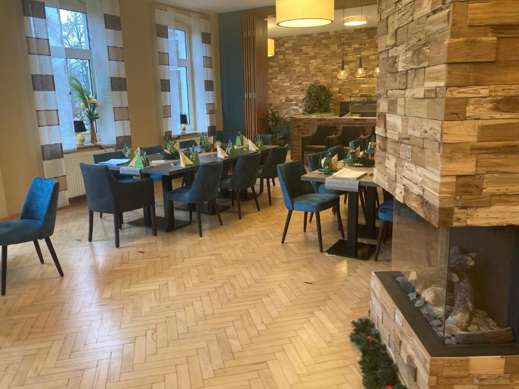 a restaurant with tables and chairs and a fireplace at MediTerra in Papenburg